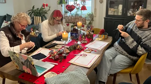 Drei Personen nähen am dekorierten Tisch.