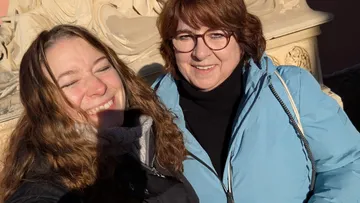 Two women smiling in bright sunlight.