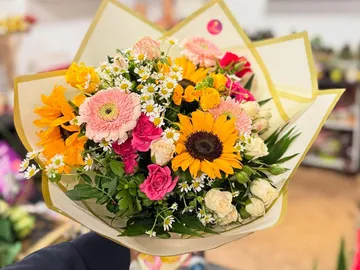 Bunter Blumenstrauß in einem Geschäft gehalten.