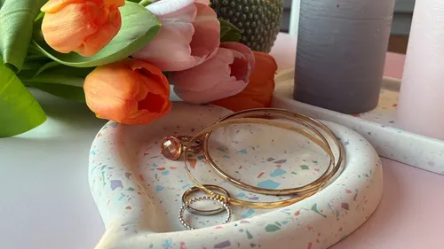 Jewelry on tray with tulips nearby.
