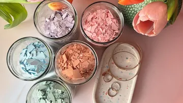Fünf Gläser mit Pastellscherben, Tulpe daneben.