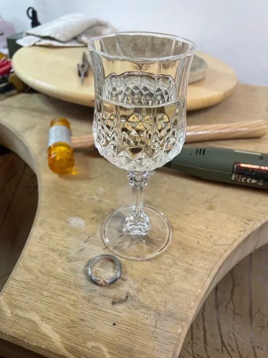 Kristallglas auf Holztisch mit Ring.