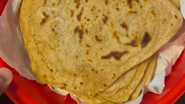Stack of flatbreads in a red bowl.