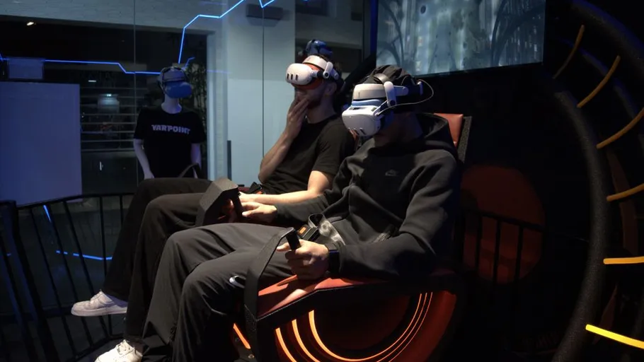 Personen mit VR-Headsets in dunklem Raum.