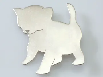 Metal figure of a dog stands on a light background.