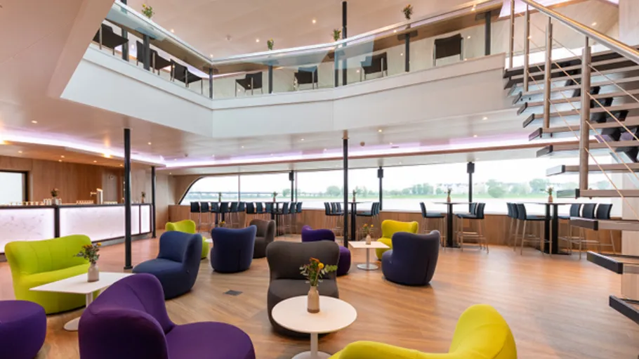 Bunte Loungesessel in modernem Schiffsinterieur.