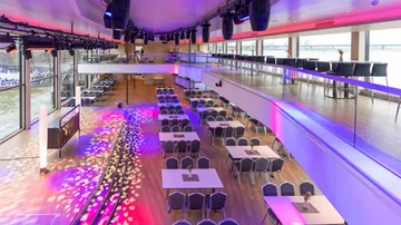 Spacious event hall with vibrant lighting.