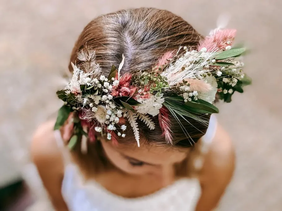 Wreath of flowers on head surrounded by blurred background.