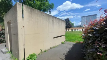 Concrete structure beside pathway in sunny park.
