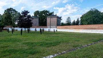 Brick wall with trees in park.