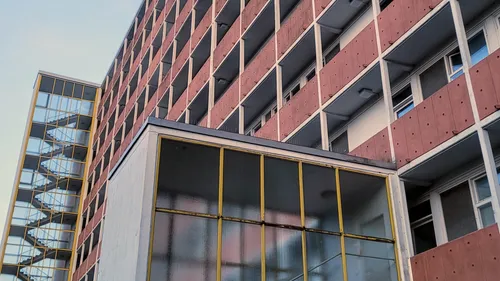 Hohes Gebäude mit sichtbaren Balkonen.