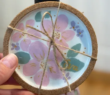 Bemalter Untersetzer mit Blumendesign, Schnur gebunden.