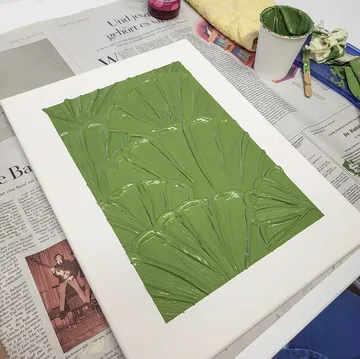 Leinwand mit grüner Texturfarbe auf Zeitung.