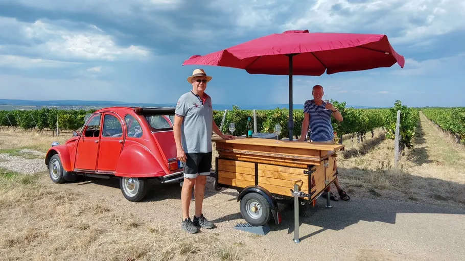 Red car and bar in vineyard setting.