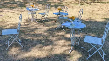 Metal bistro tables and chairs on grass