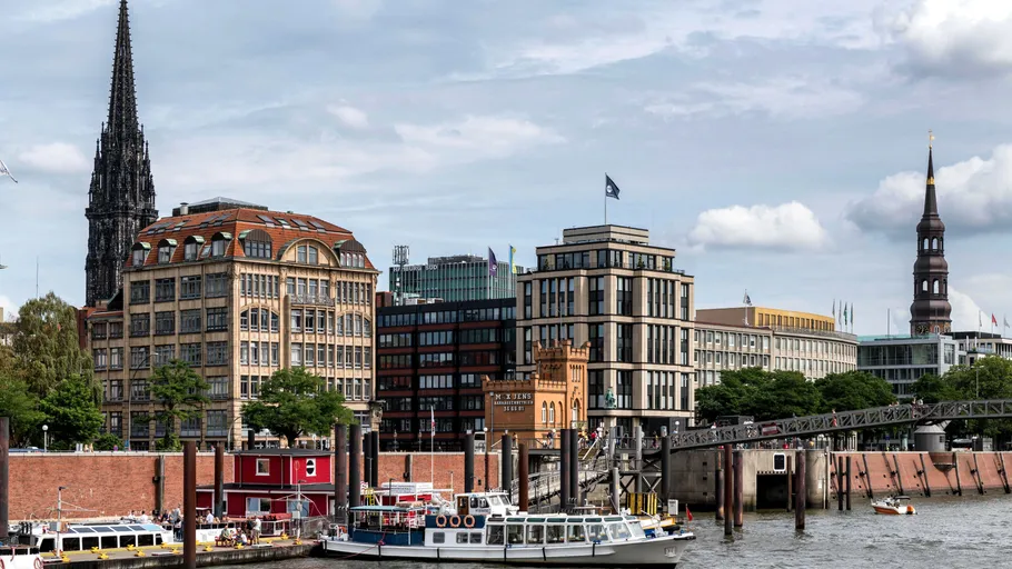 Boote auf Fluss mit Stadtgebäuden im Hintergrund.