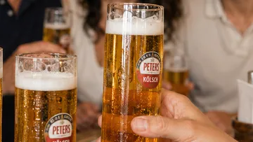 Gläser Bier werden zum Anstoßen gehoben.