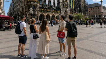 Gruppe macht Sightseeing auf Stadtplatz, historisches Gebäude.
