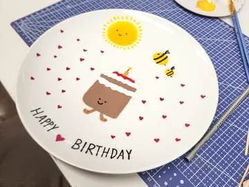 Plate with cake, bees, and sun design.