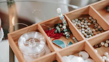 Perlen in Holzkasten für Schmuck sortiert.