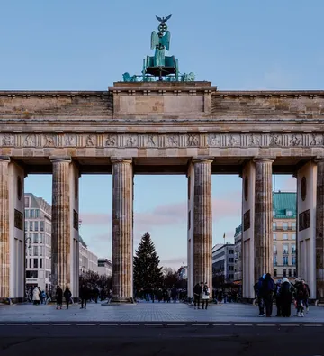 Brandenburger Tor mit Menschen und Weihnachtsbaum.