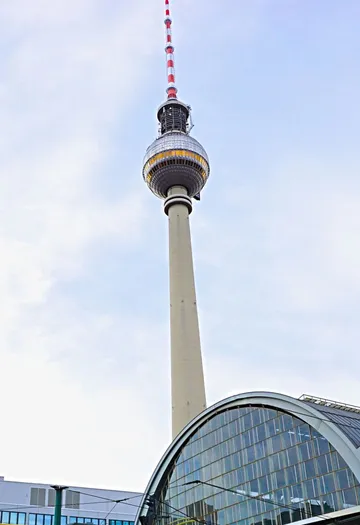 TV tower towering over modern building.