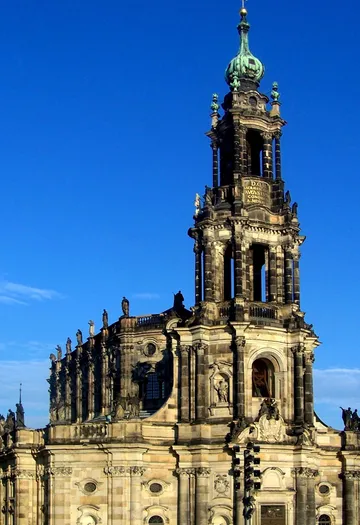 Historischer Kirchturm vor blauem Himmel.