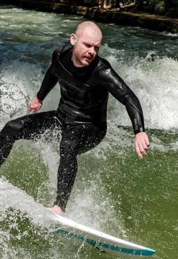 Surfer reitet eine Welle im Neoprenanzug.