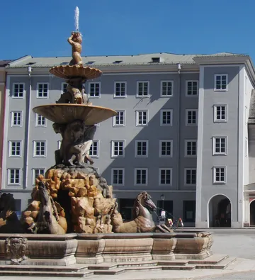 Brunnen mit Skulpturen auf städtischem Platz.