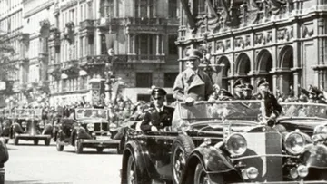 Vintage parade with cars in a city.