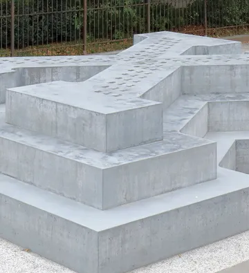 Concrete crosses in outdoor garden setting.