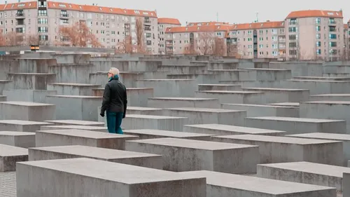 Person walks through concrete memorial blocks.