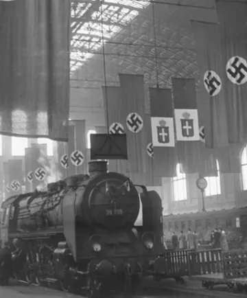 Dampflok in Nazi-dekoriertem Bahnhof geparkt.