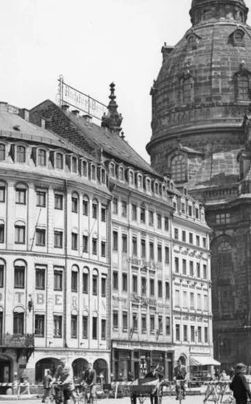 Historische Stadtstraße mit vorbeifahrenden Radfahrern.