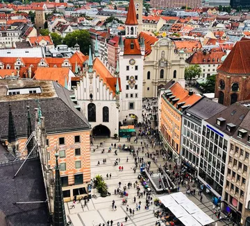 Uhrturm überblickt belebten Stadtplatz.