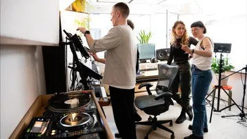 Gruppe von Menschen arbeitet im Musikstudio.