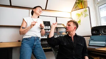 Zwei Personen diskutieren im Musikstudio.