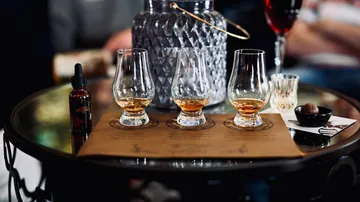 Drei Whisky-Gläser auf einem Tisch.