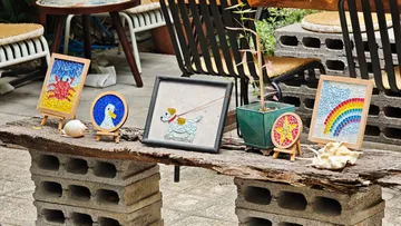 Mosaic art displayed on rustic outdoor bench.