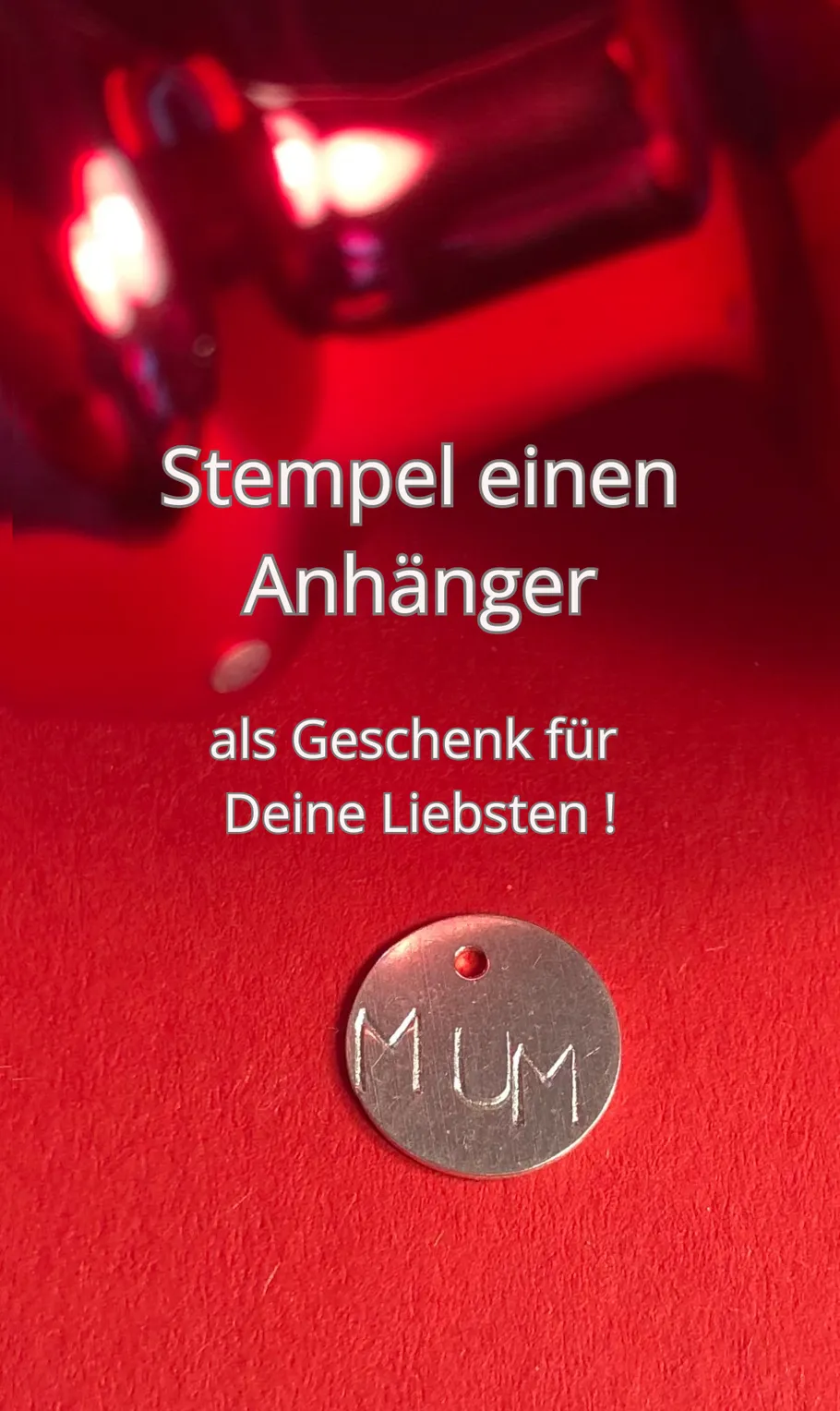Runder Anhänger mit 'MUM' auf rotem Hintergrund.