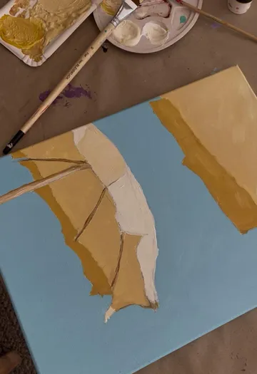Painting of umbrella on a canvas. Workspace visible.