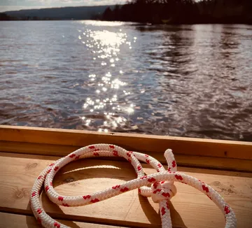 Rope lies coiled on wooden boat deck.