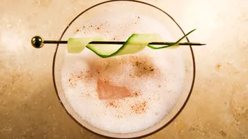 Cocktail mit Schaum, Gurkengarnitur, Tischplatte