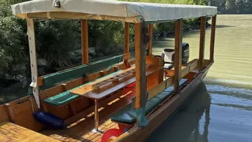 Holzboot vertäut an einem ruhigen Fluss.