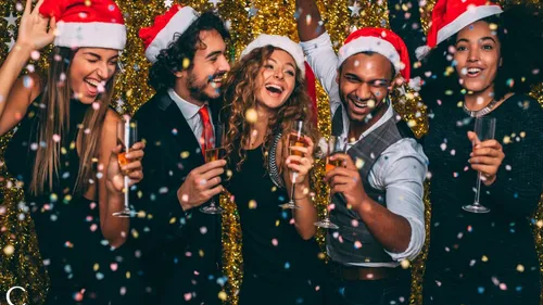 People celebrating in Santa hats indoors.