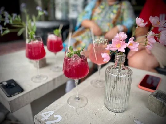 Rosa Getränke mit Blumen auf einem Tisch.
