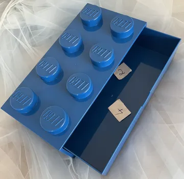 Blue LEGO box open in white fabric.