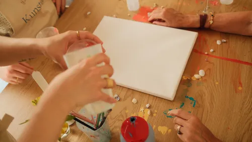 Hands preparing to paint canvas on table.