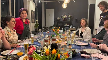 Menschen essen an einem Tisch mit Tulpen.