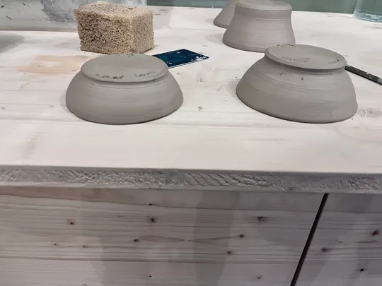 Tonschalen trocknen auf einem Holztisch.